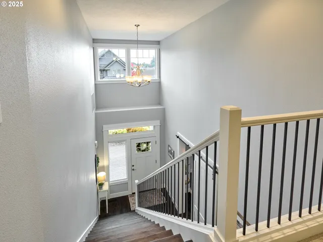 a view of hallway with wooden floor and stairs