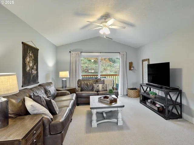 a living room with furniture a flat screen tv and a large window