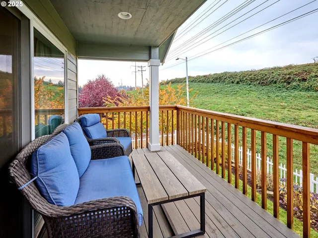 a balcony with wooden floor table and chairs