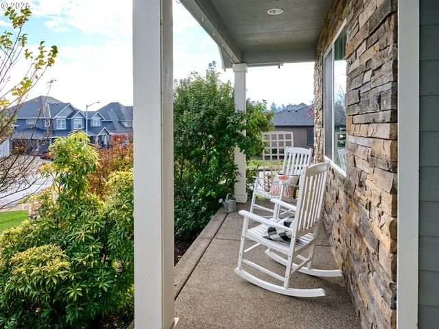 a view of a porch with a bench and potted plants