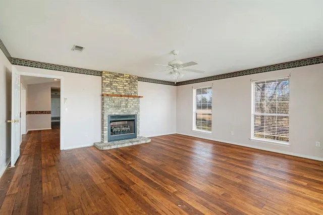 a view of empty room with wooden floor and fireplace