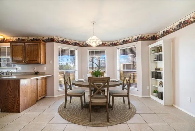 a spacious bedroom with a bed a chandelier and a window