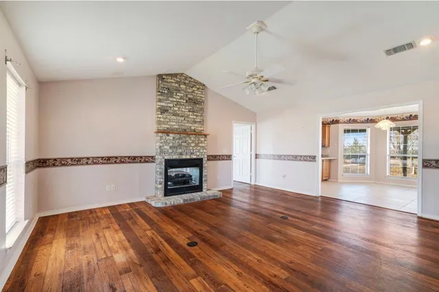 a view of empty room with wooden floor and fireplace