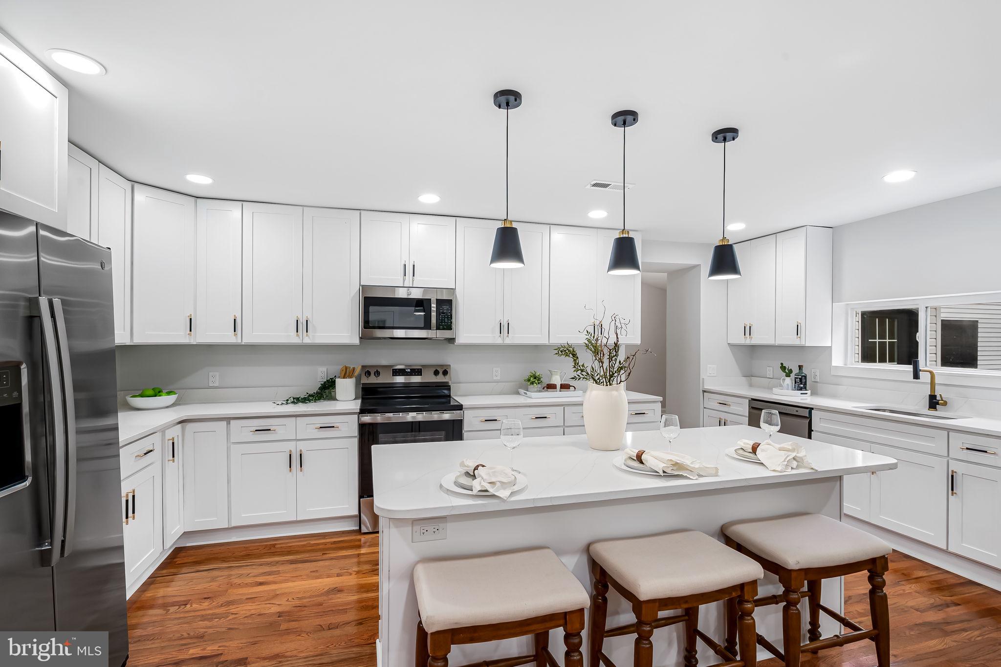 6751 White Rock Road Sykesville, MD 21784 - Photo 12 of 44 a kitchen with stainless steel appliances kitchen island granite countertop a sink a stove a refrigerator and white cabinets with wooden floor