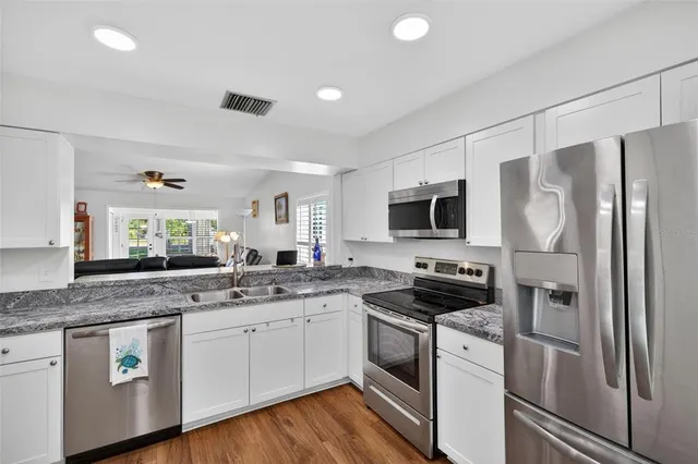 a kitchen with a sink stove cabinets and refrigerator