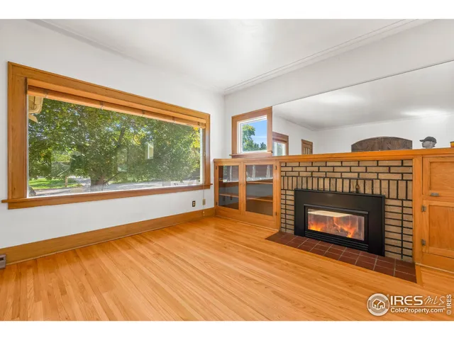 a view of empty room with wooden floor and fireplace