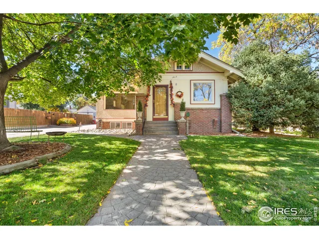 a front view of a house with a yard and trees