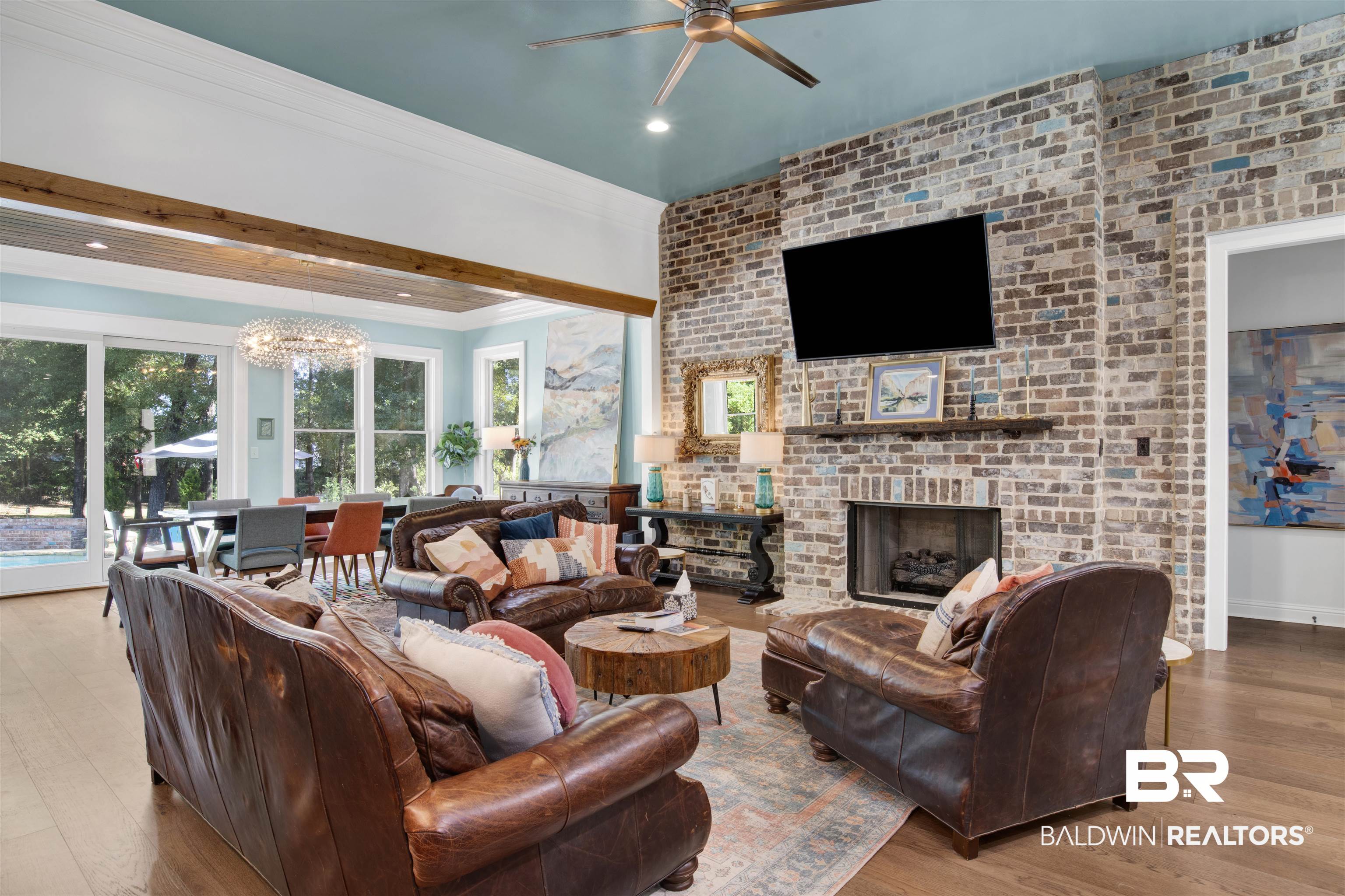 11116 Redfern Road Daphne, AL 36526 - Photo 19 of 46 Living area featuring wood finished floors, a chandelier, a brick fireplace, brick wall, and ornamental molding