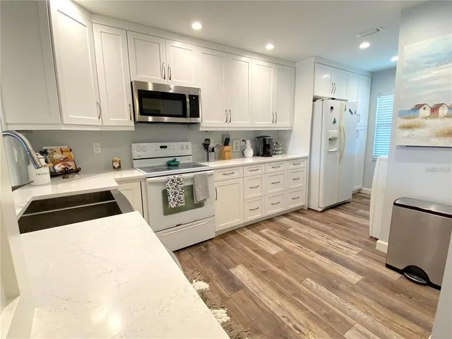a kitchen with stainless steel appliances granite countertop a stove a sink and a refrigerator