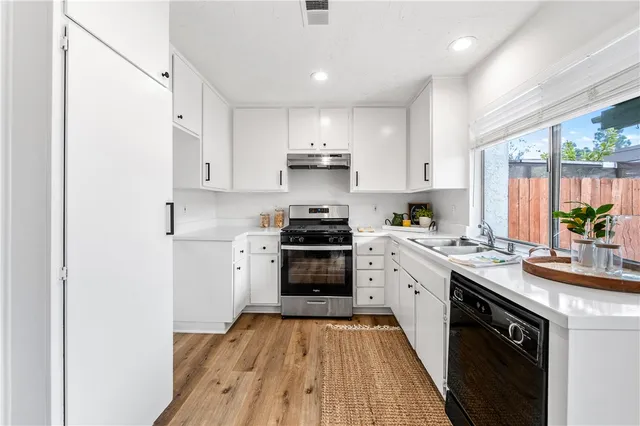 a kitchen with a stove top oven sink and cabinets