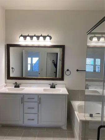 a bathroom with a tub sink and mirror