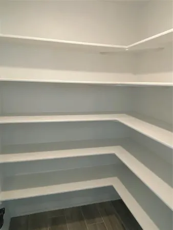 a view of a closet with wooden floor