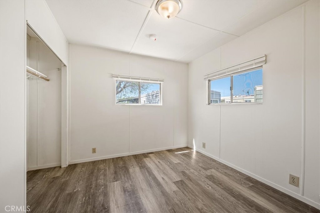 3210 Santa Maria Way, Unit 49 Santa Maria, CA 93455 - Photo 27 of 50 a view of an empty room with wooden floor and a window