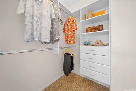 a view of walk in closet with clothes and shoes