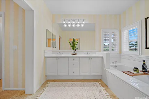 a bathroom with a tub a sink and a window