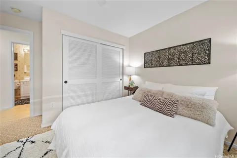 a bedroom with a large bed and wooden floor