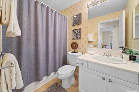 a bathroom with a sink a toilet and shower curtain