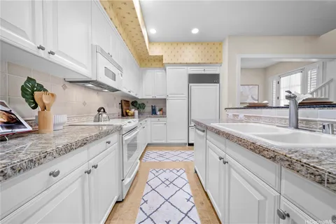 a large kitchen with stainless steel appliances granite countertop a sink stove and cabinets