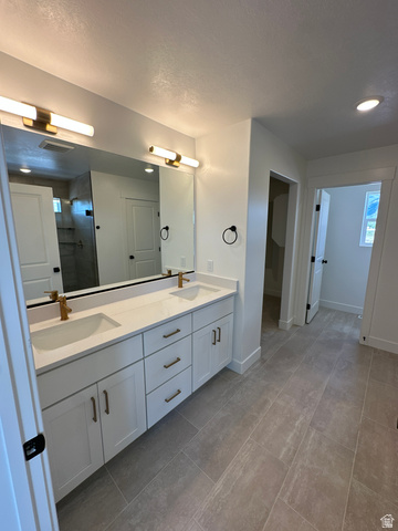 1225 West 500 South Logan, UT 84321 - Photo 34 of 39 Dual vanity with white cabinetry, gold-tone hardware, and white countertops