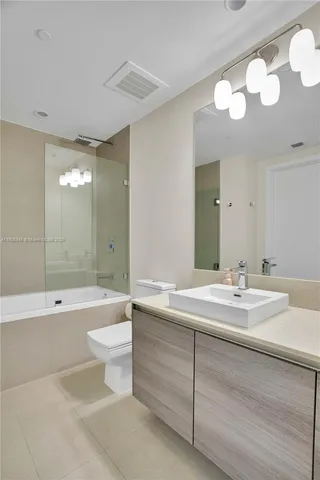 a bathroom with a bathtub a mirror a toilet a sink and window