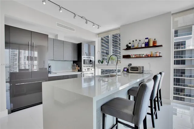 a kitchen with granite countertop stainless steel appliances a table and chairs in it