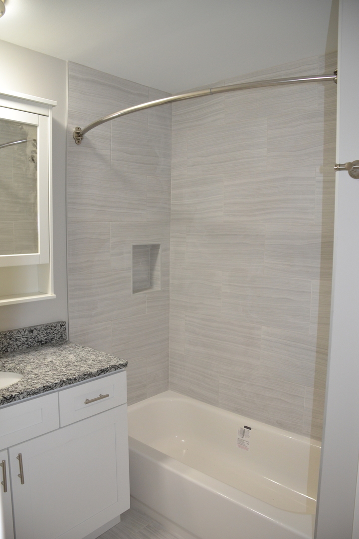 739 Hibbard Road Wilmette, IL 60091 - Photo 13 of 17 a bathroom with a granite countertop bathtub shower and vanity