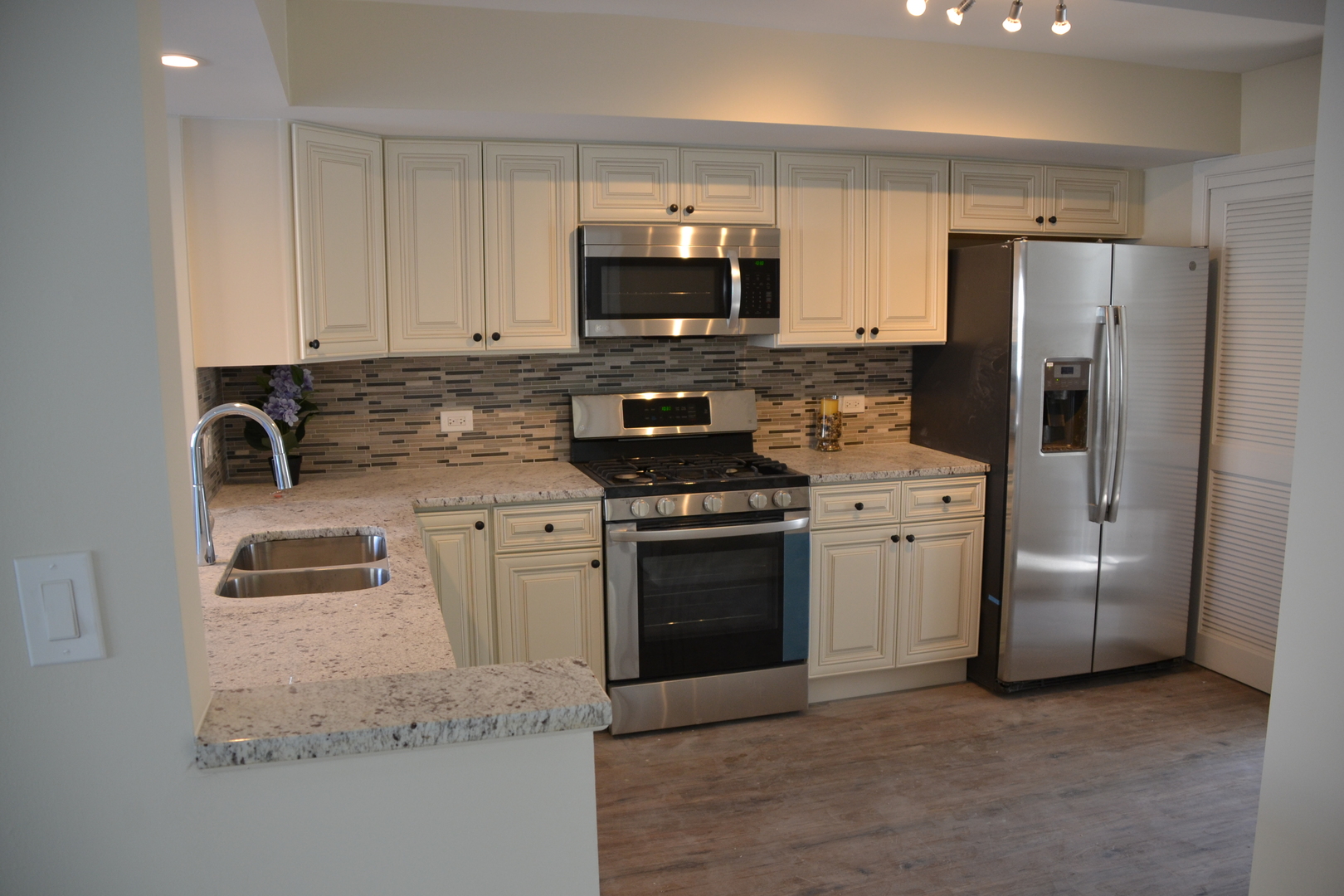 739 Hibbard Road Wilmette, IL 60091 - Photo 3 of 17 a kitchen with stainless steel appliances granite countertop a stove a refrigerator and a microwave