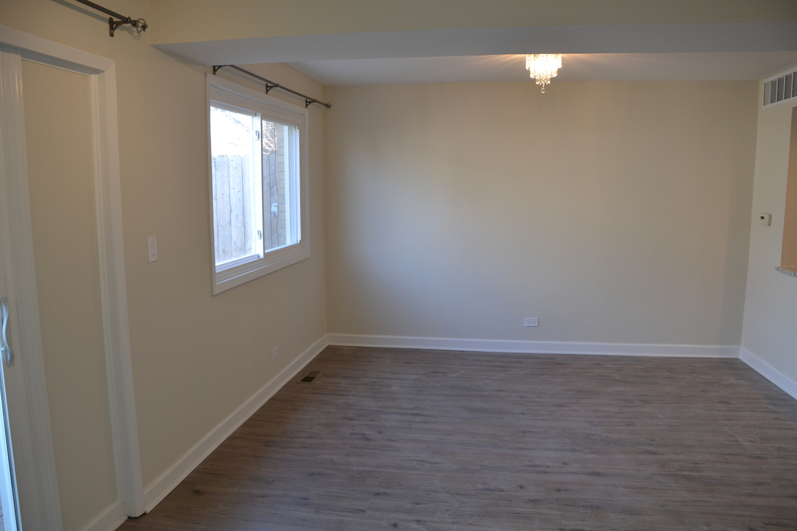 739 Hibbard Road Wilmette, IL 60091 - Photo 6 of 17 a view of an empty room with wooden floor and a window