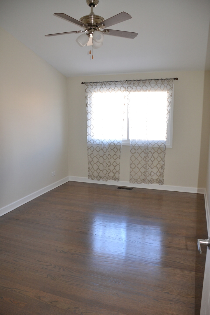 739 Hibbard Road Wilmette, IL 60091 - Photo 8 of 17 an empty room with wooden floor and windows