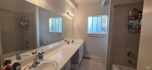 a bathroom with a granite countertop sink mirror and shower
