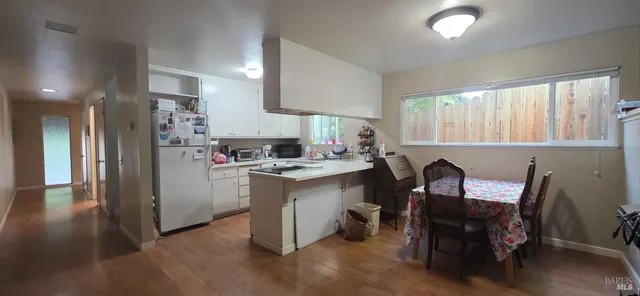 a kitchen with a sink a refrigerator and chairs
