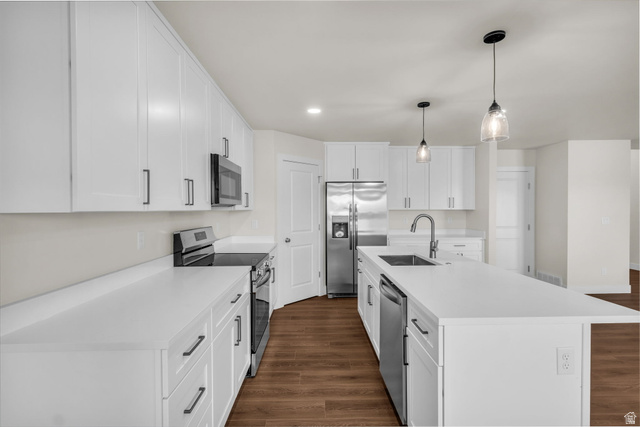 578 West 7th Midvale, UT 84047 - Photo 7 of 35 Kitchen with stainless steel appliances, white cabinetry, dark wood finished floors, and a center island with sink