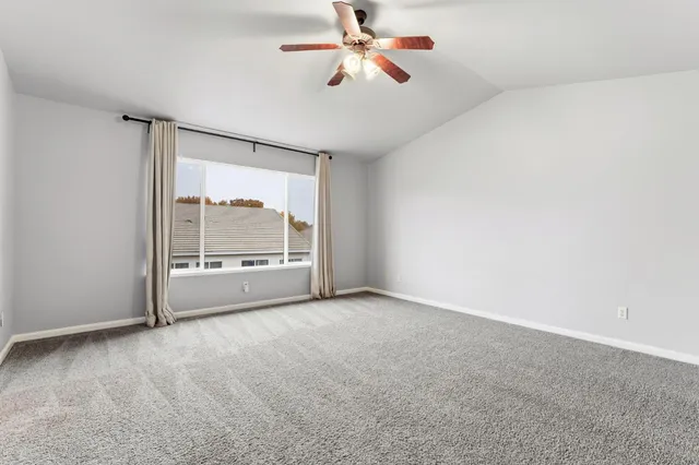 a view of a room with a ceiling fan and window
