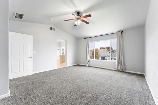 an empty room with fan and windows