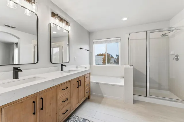 a spacious bathroom with a double vanity sink mirror double and shower