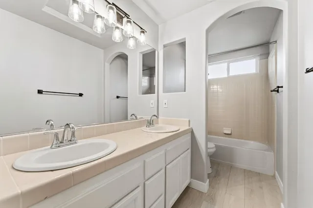 a bathroom with a toilet a sink a mirror and a shower