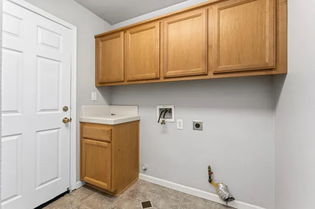 a utility room with granite countertop cabinets washer and dryer