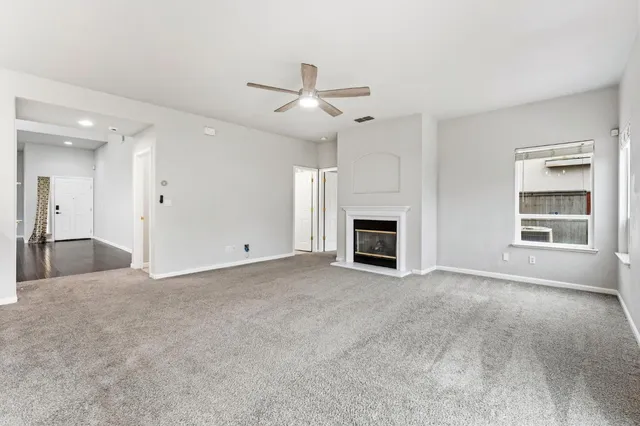 an empty room with windows and fireplace