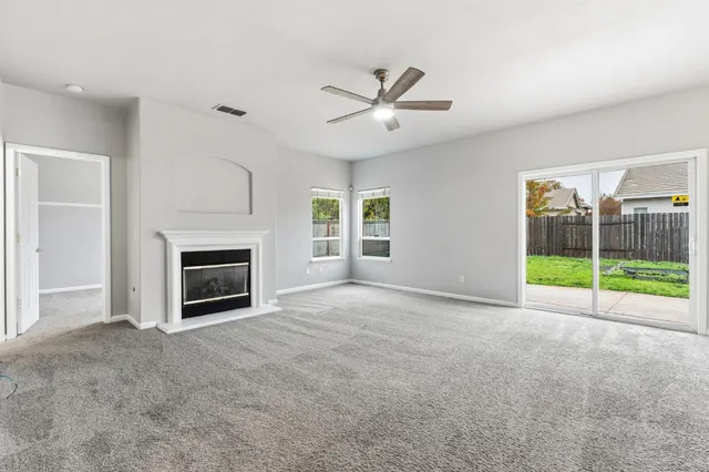 a view of an empty room with a fireplace and a window