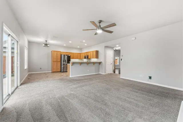 a view of a big room with wooden floor and windows
