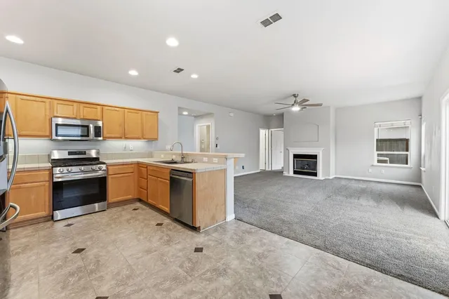 a kitchen with a sink and steel appliances