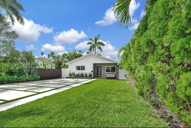 a view of a house with a yard and potted plants