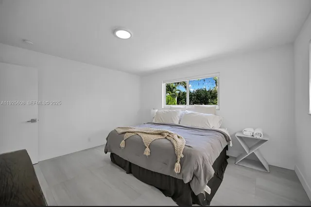 a bed sitting in a bedroom next to a window