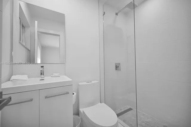 a bathroom with a toilet a sink a mirror and vanity