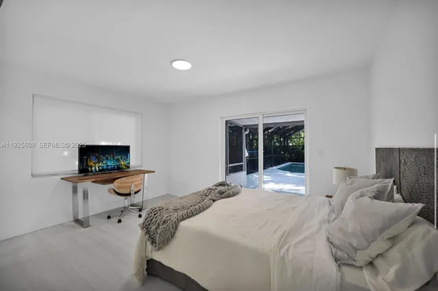 a bedroom with a bed and large windows