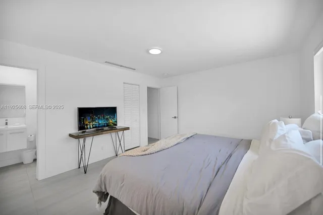 a bedroom with a bed and a flat screen tv