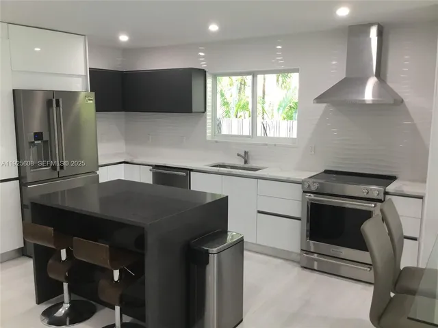 a kitchen with a sink a stove a refrigerator and a microwave