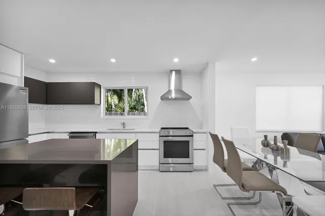 a kitchen with a table chairs microwave and cabinets
