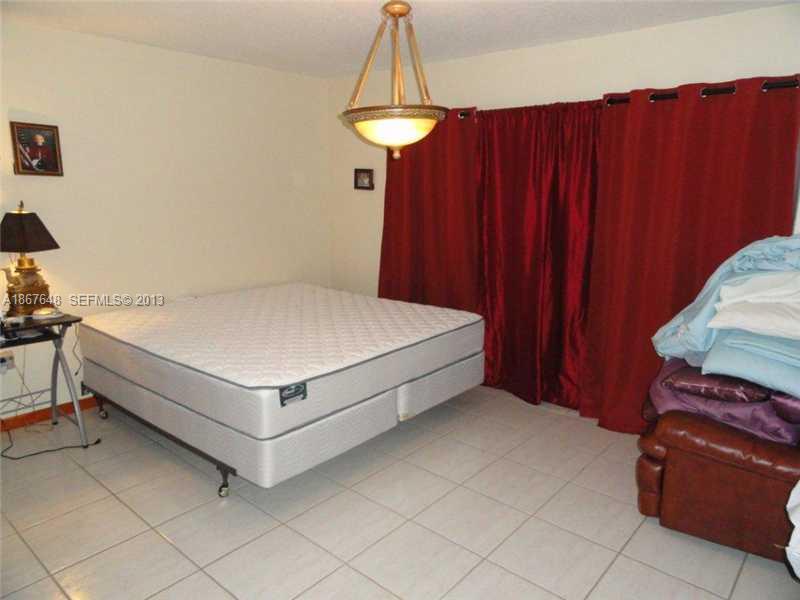 15636 Southwest 35th Terrace Miami, FL 33185 - Photo 12 of 18 a bedroom with a bed and a table