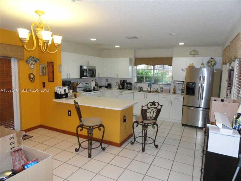 15636 Southwest 35th Terrace Miami, FL 33185 - Photo 4 of 18 a room with stainless steel appliances a dining table chairs refrigerator and sink